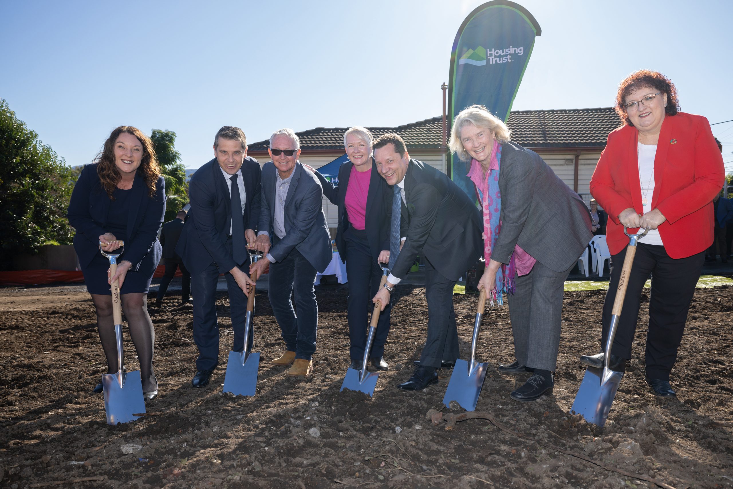 Group of people with shovels digging into ground