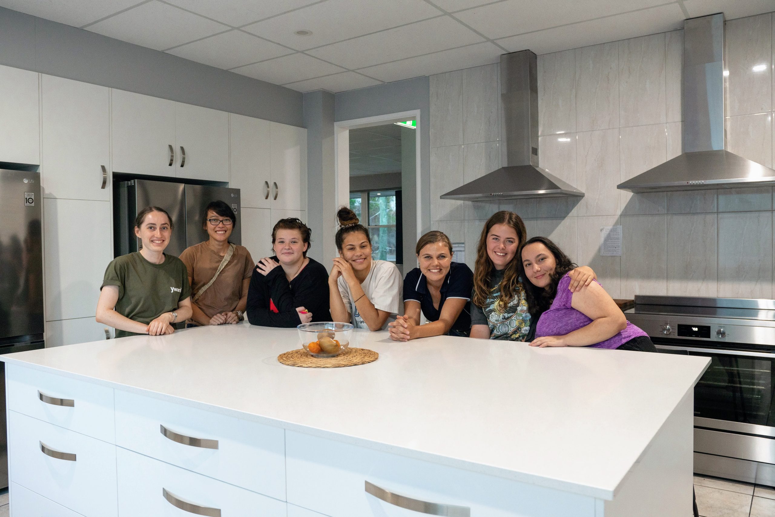 Group of women gathered around a kitchen island